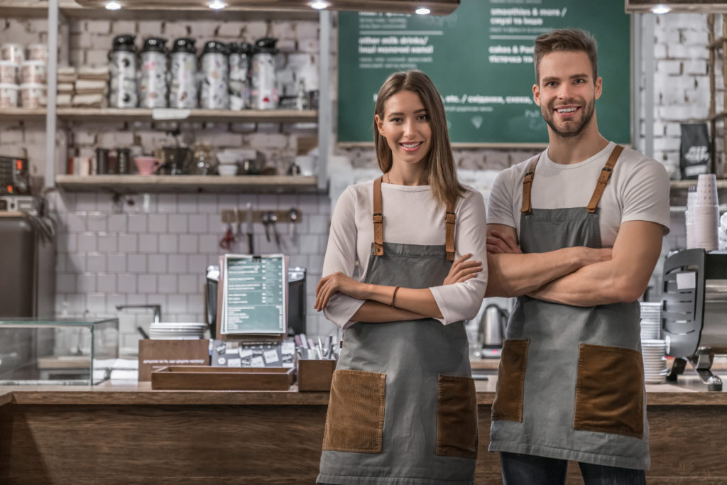 Portrait of successful business coffee shop owners indoors